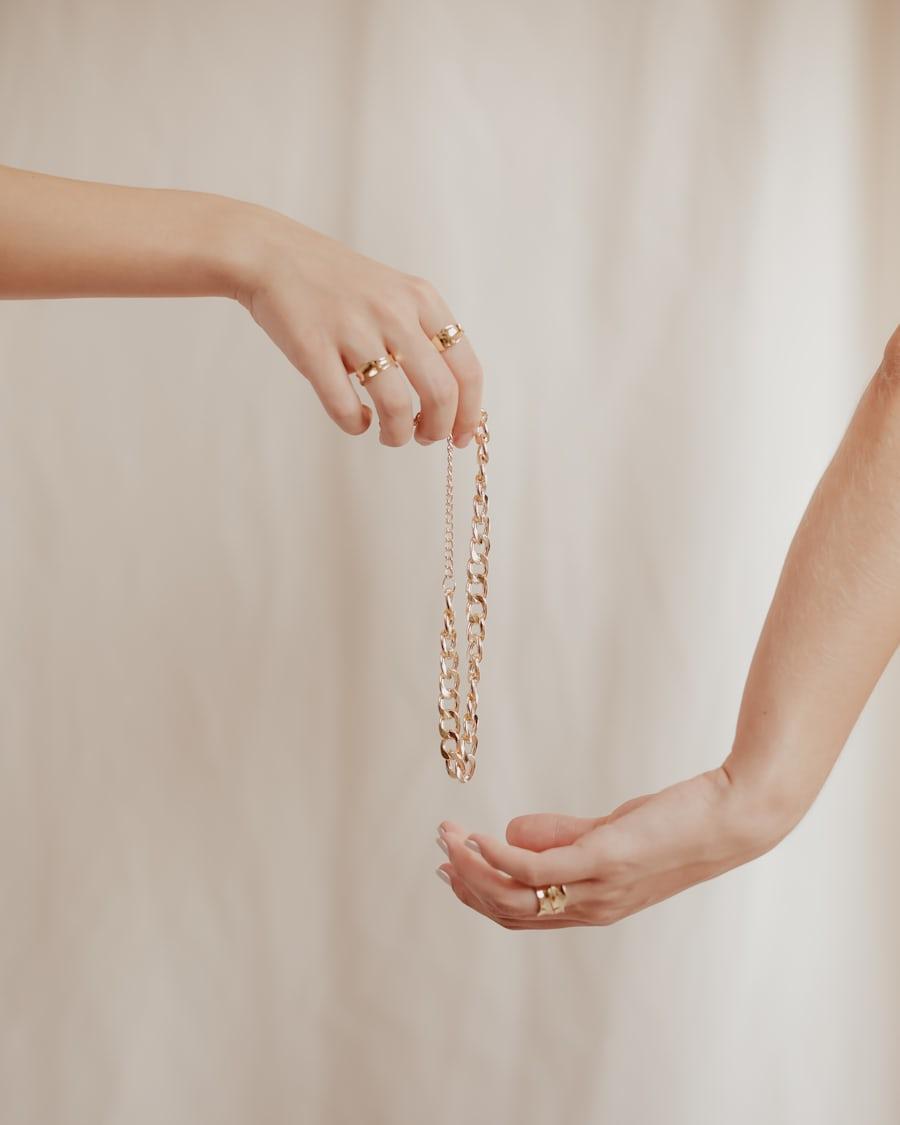Hands holding a gold chain
